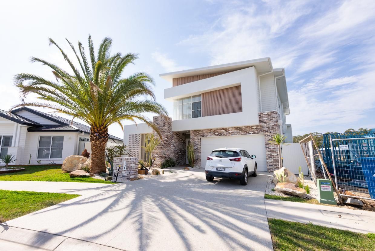 A Large Crane is Lifting a Metal Structure on a Construction Site — Roofing Contractor in Wauchope, NSW