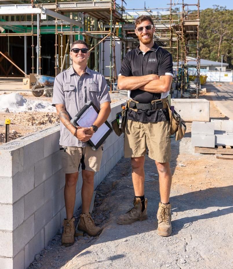 A Man is Sitting on Top of a Metal Structure at a Construction Site — Roofing Contractor in Wauchope, NSW