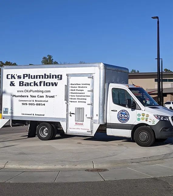 CK’s Plumbing & Backflow service truck parked on a street under a blue sky