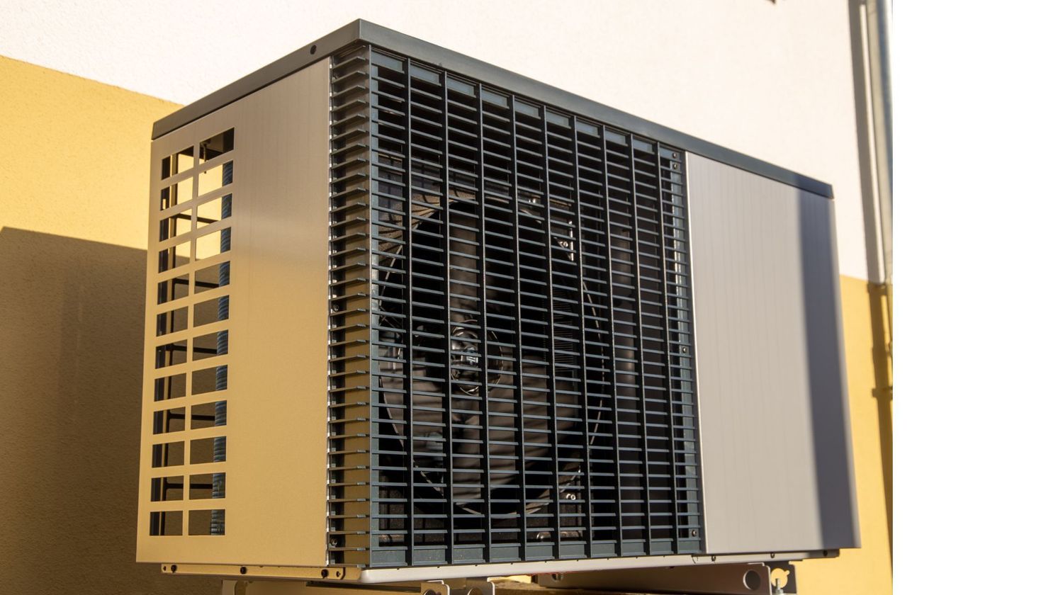 A large air conditioner is mounted on the side of a building.