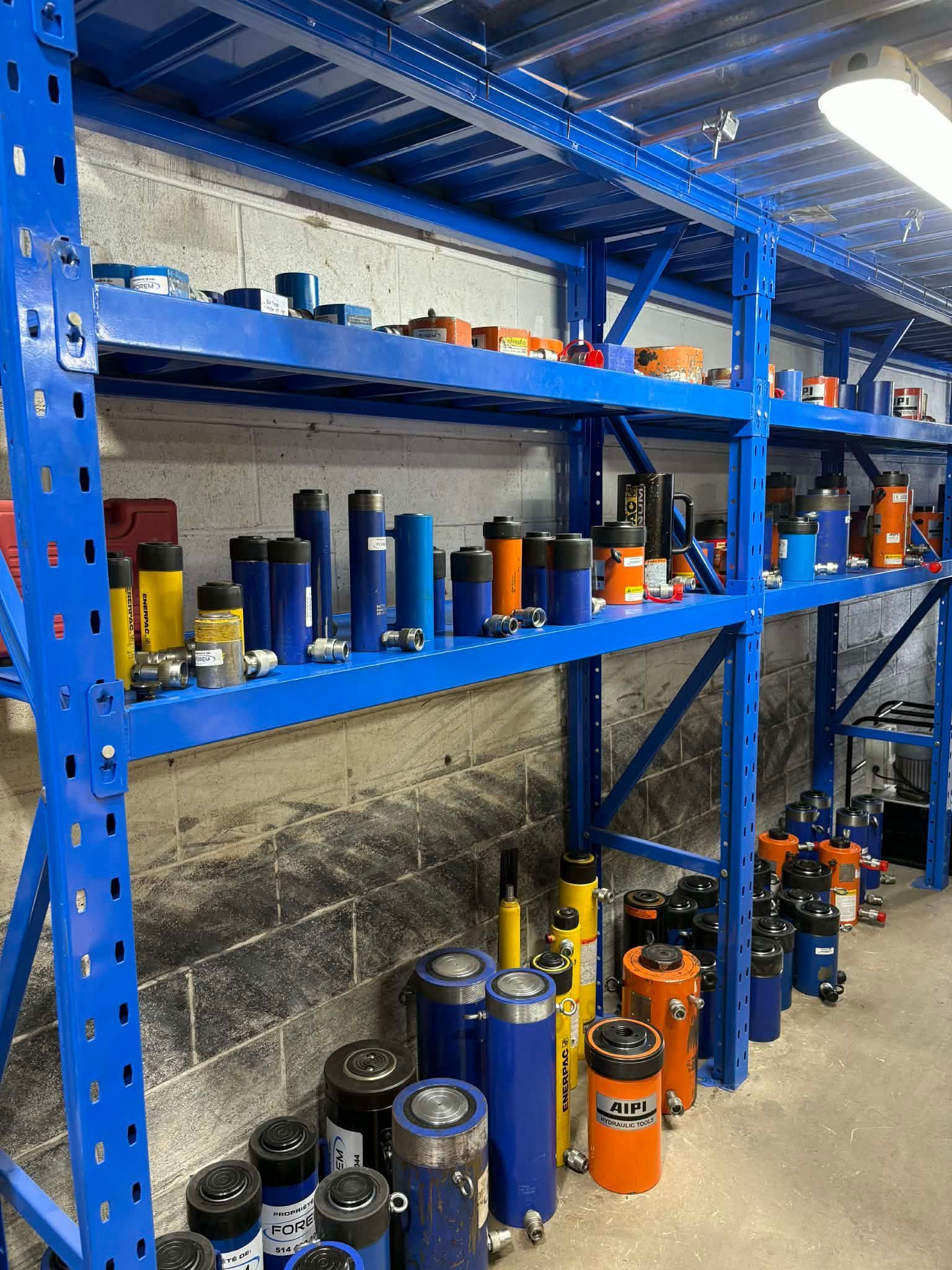 Étagères métalliques bleues remplies de pièces industrielles dans un entrepôt.