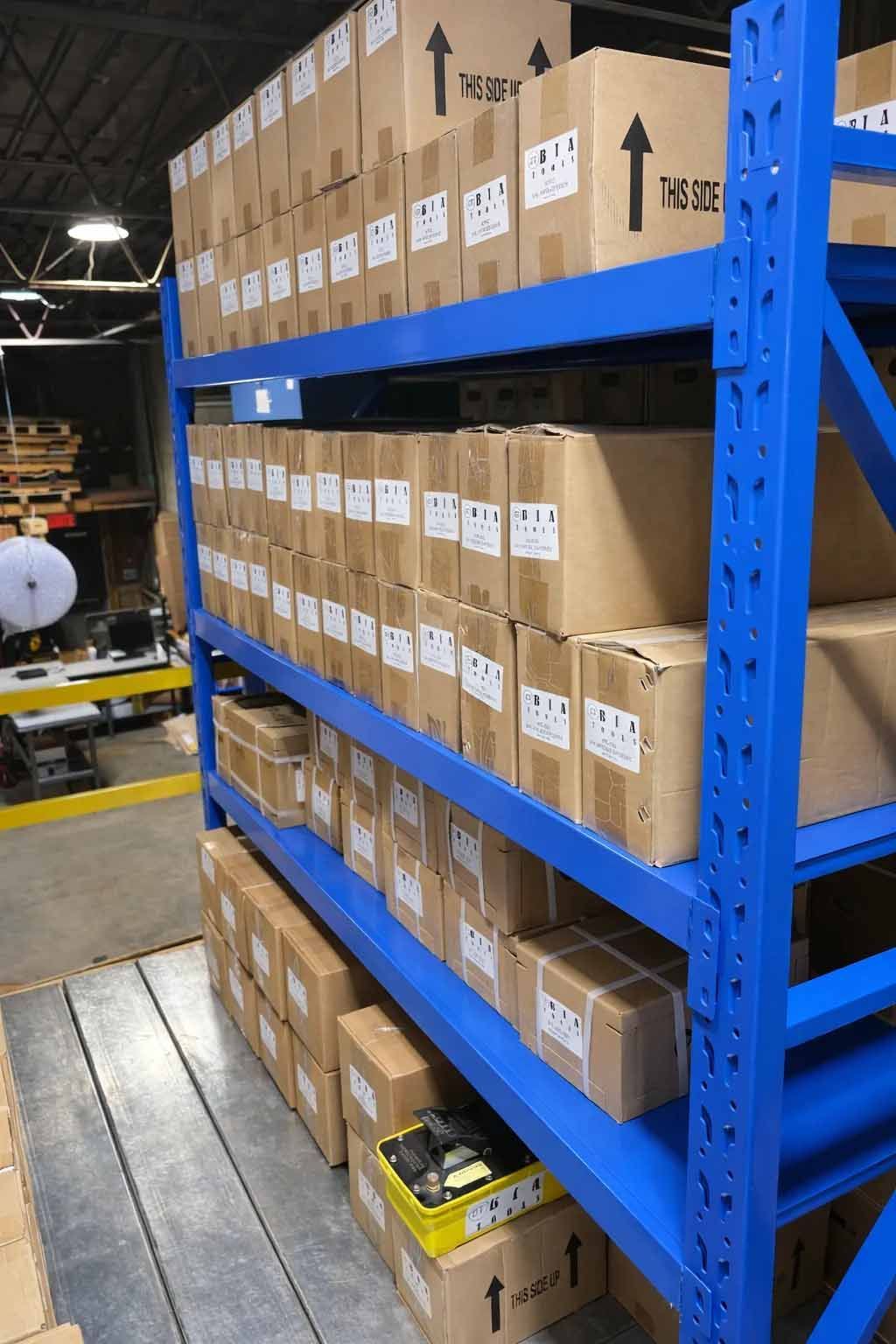Une étagère industrielle en métal bleu remplie de nombreux cartons dans un entrepôt.