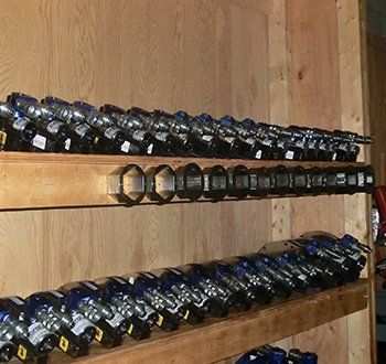 Des rangées d'outils industriels bleus et noirs sur des étagères en bois.