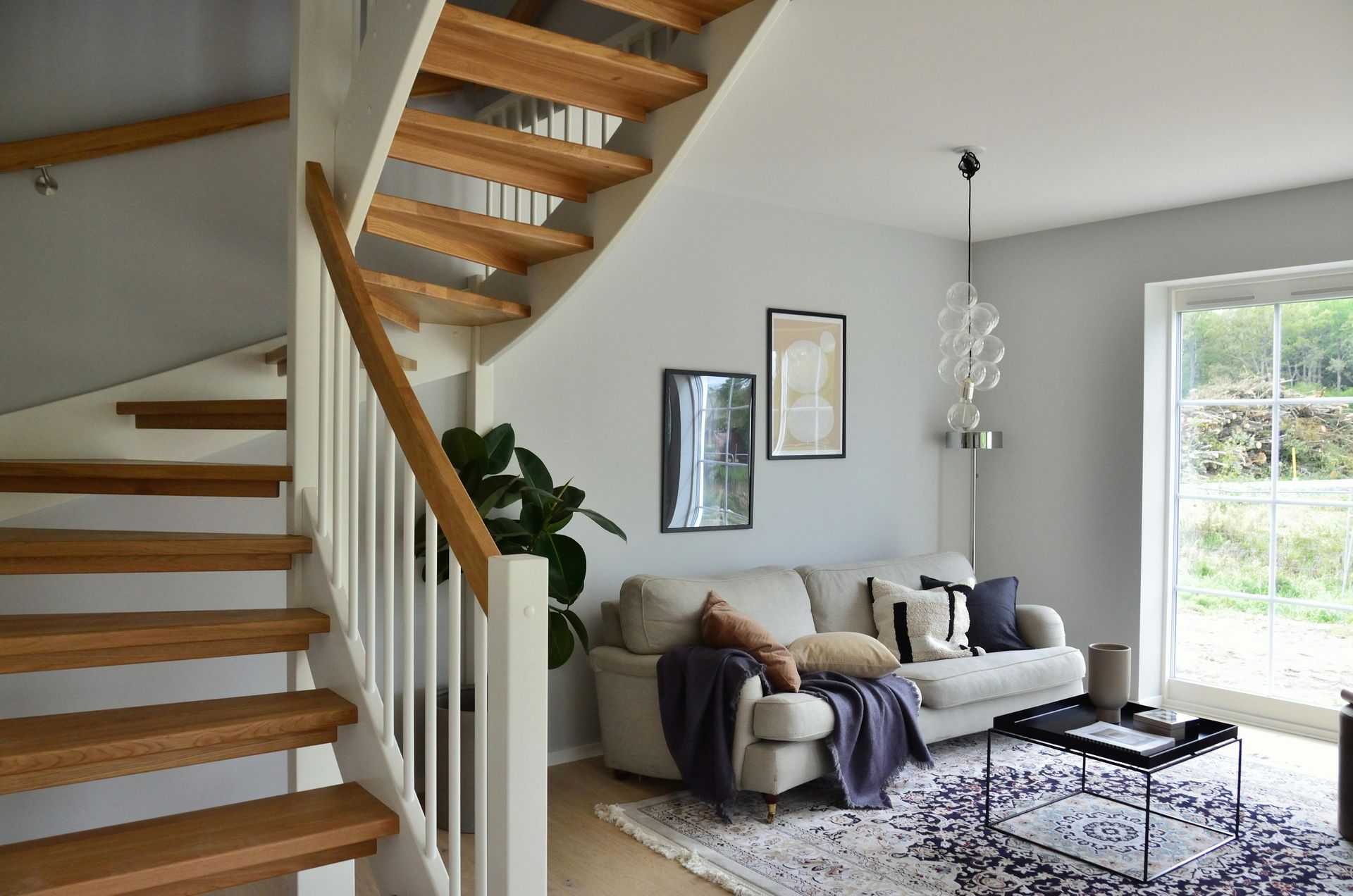 A living room with a couch and stairs leading up to the second floor.
