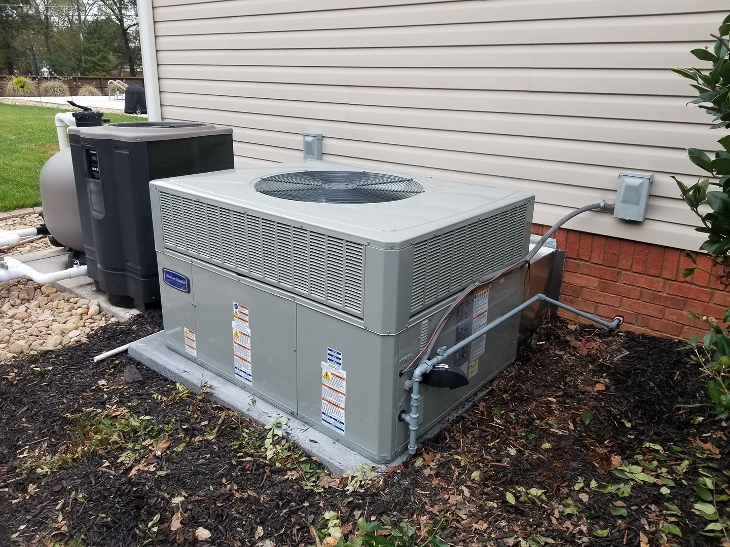 A large air conditioner is sitting on the side of a house.