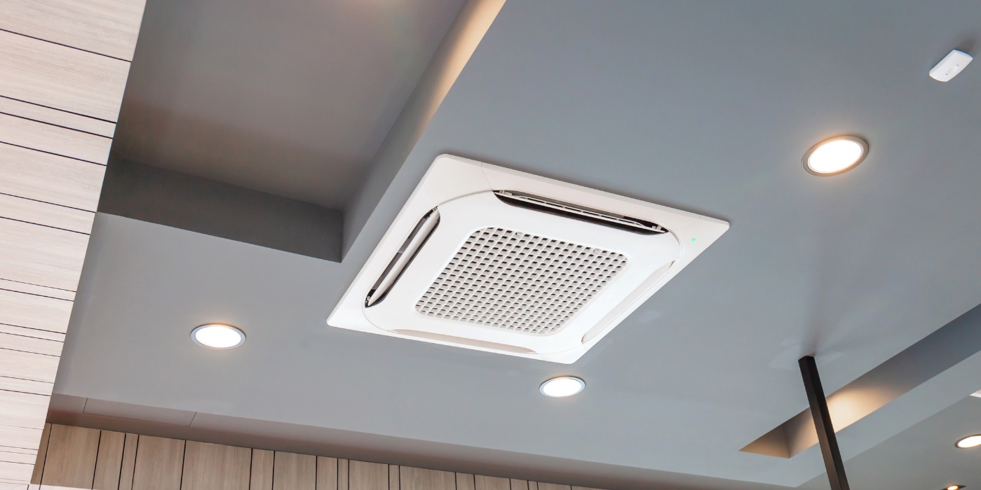 A square air conditioner is hanging from the ceiling of a room.