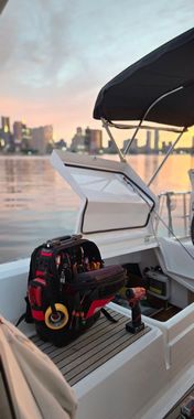 The Boston skyline viewed from the harbor, featuring tall buildings and boats docked at a waterfront pier at sunset.