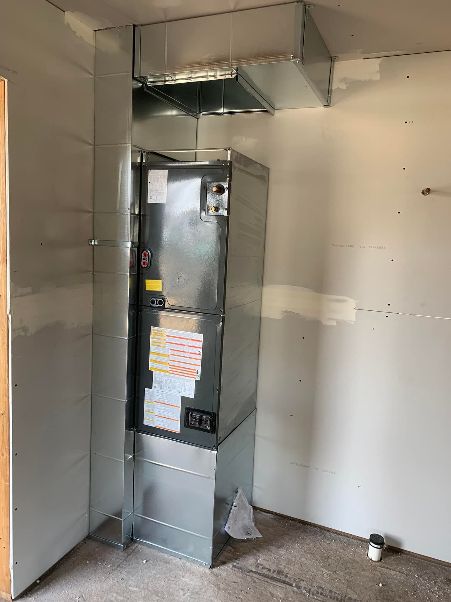 A refrigerator is sitting in a room next to a wall.