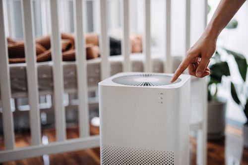 A Person Is Pointing At A Air Purifier In Front Of A Crib - Maricopa, AZ - Eco Mechanical LLC