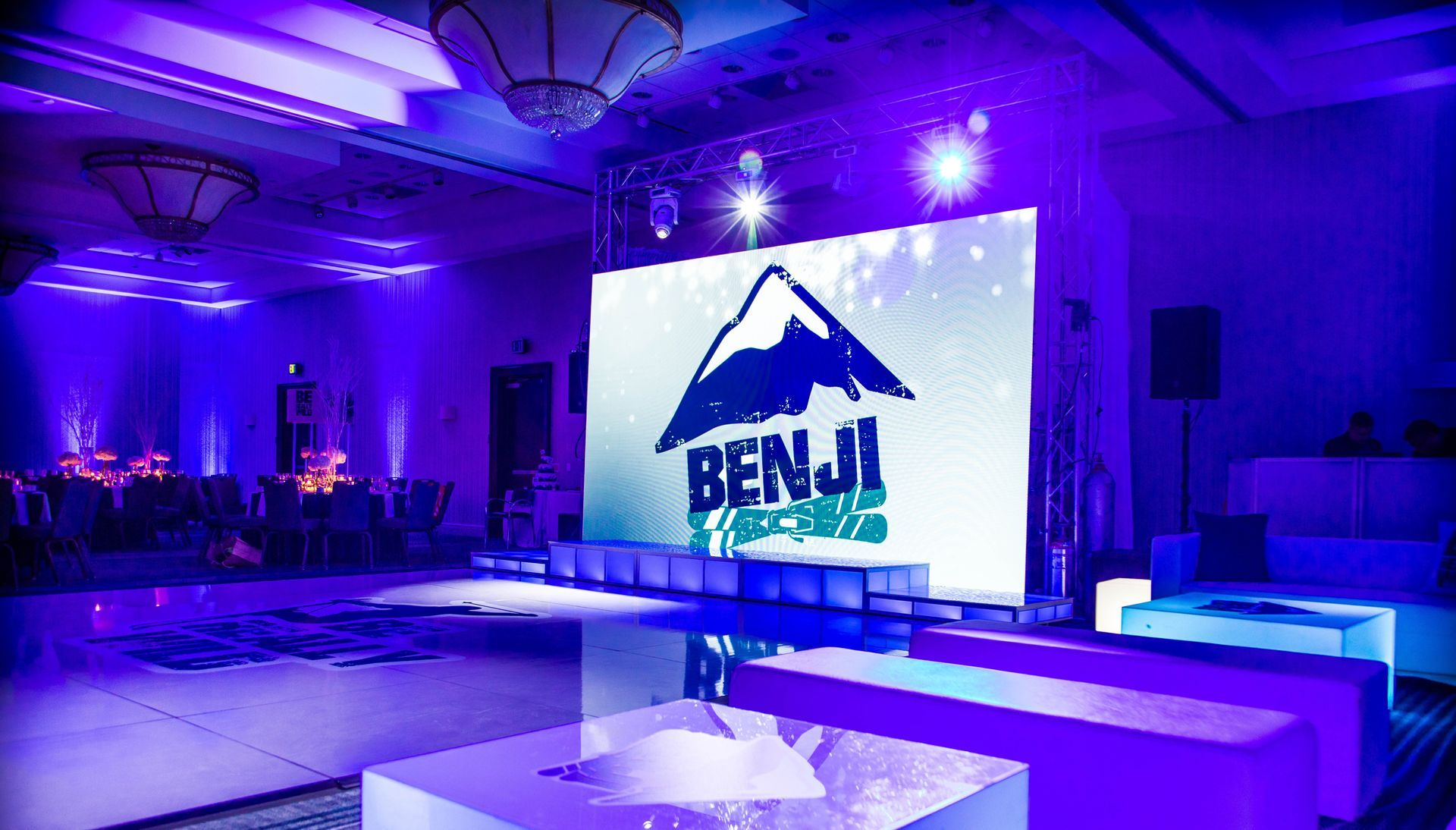 Modern lounge setup with stylish blue lighting, sleek furniture, and luxury event décor ideal for upscale celebrations.