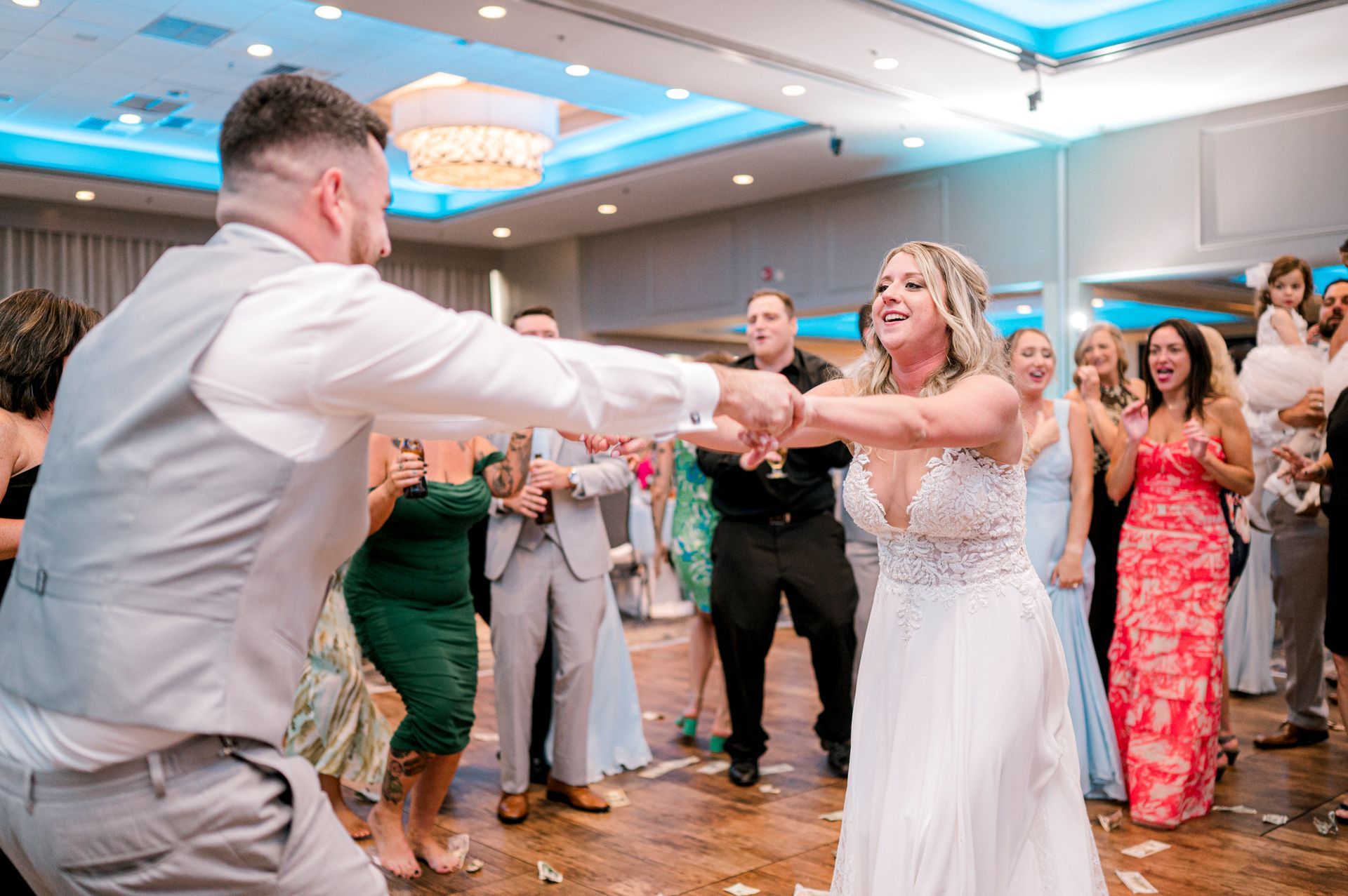 Bride dancing with groom on the dance floor during a lively wedding reception, highlighting a fun and energetic celebration.