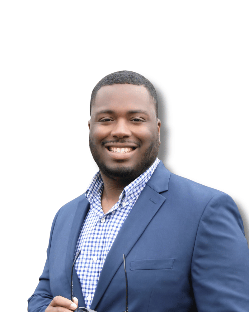 Smiling person wearing a blue blazer and blue-and-white checkered shirt, holding glasses.