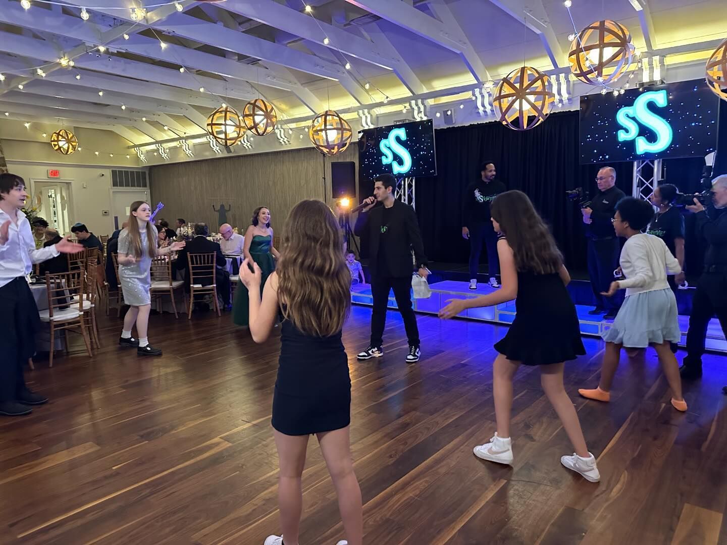 Mitzvah DJ party with fog machine and energetic crowd enjoying the lively atmosphere.