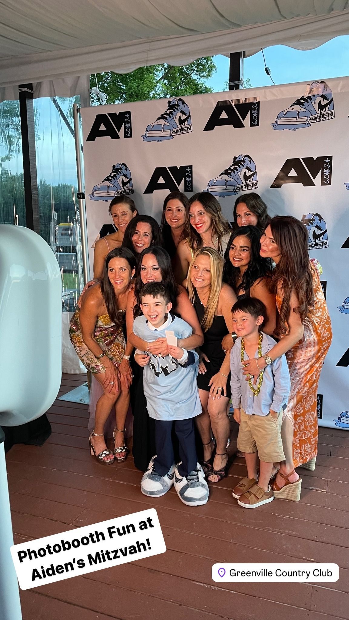 A group of people are posing for a picture in front of an open air photo booth.