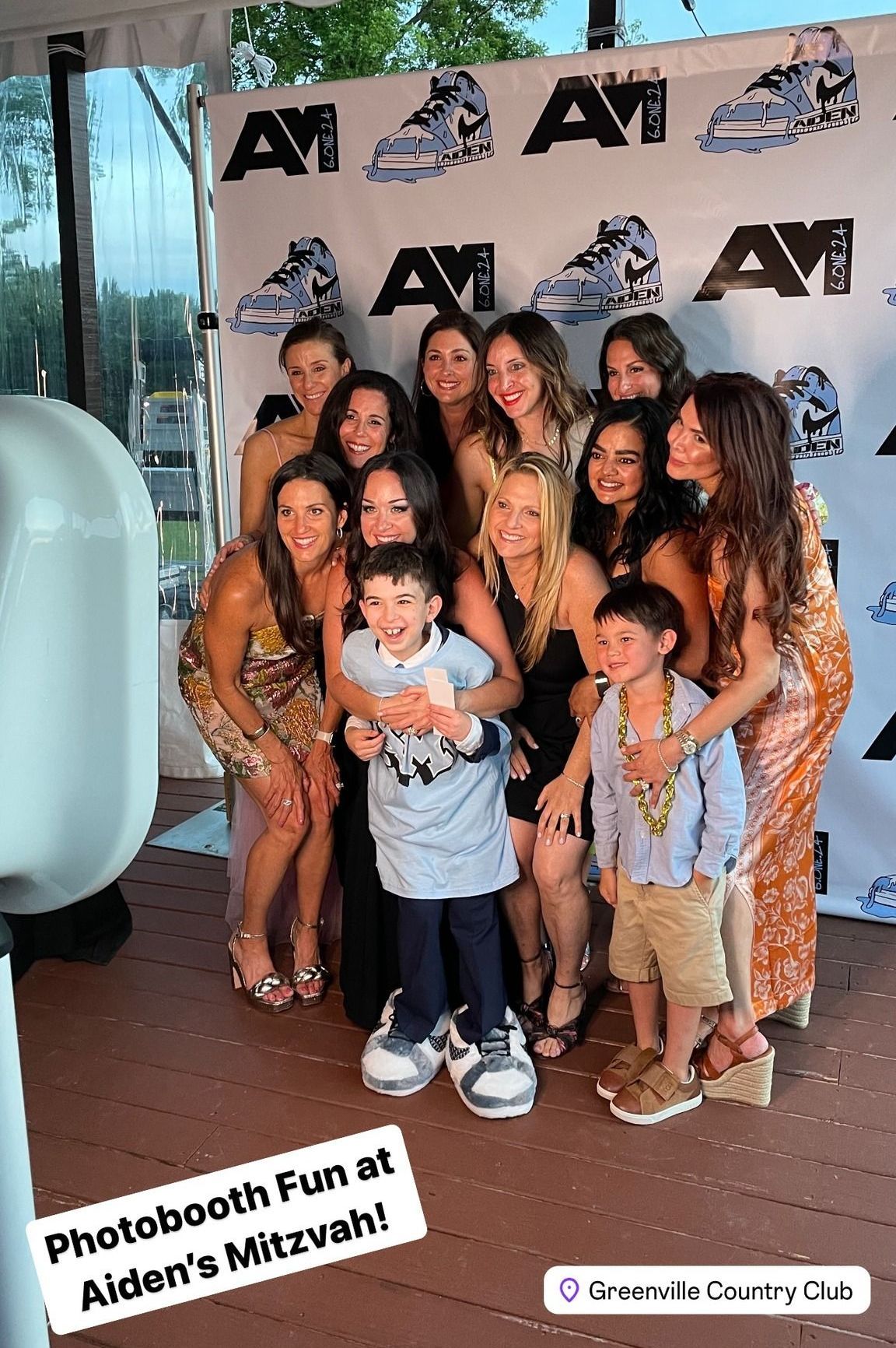 A group of people are posing for a picture in front of an open air photo booth.