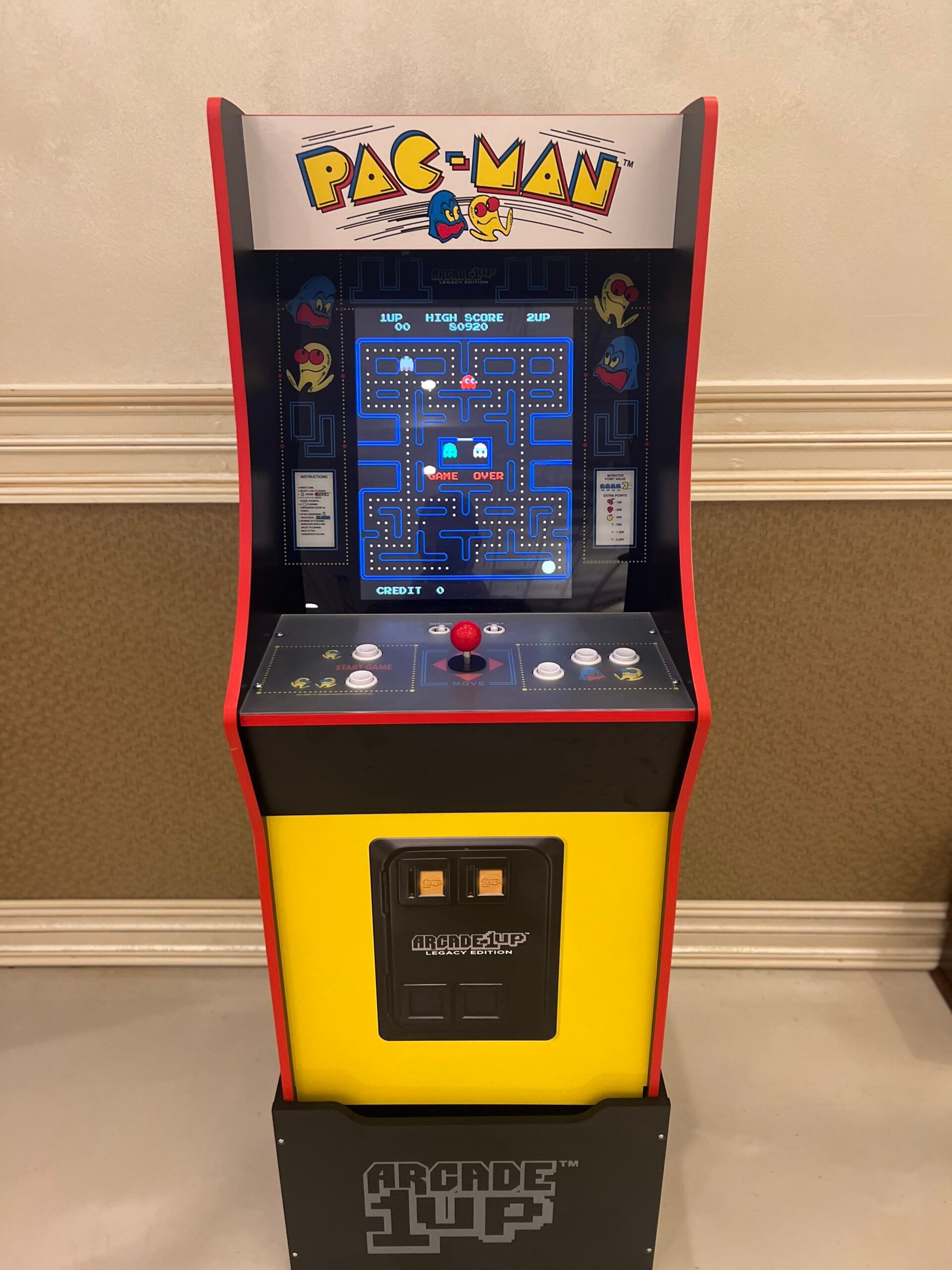 Red and white carnival tents set up indoors, featuring classic midway games and staff in referee shirts for a fun party experience.