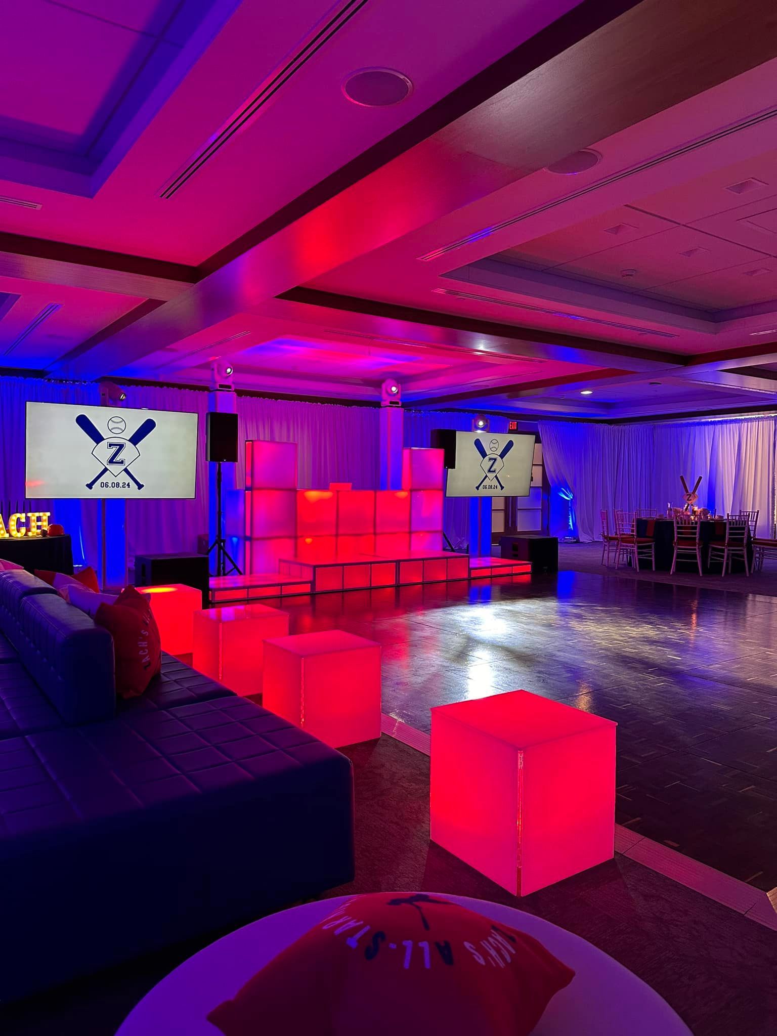 A large room with purple lights and red cubes on the floor.