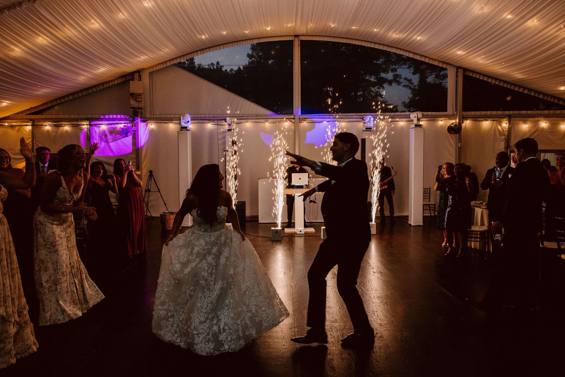 Bride and groom share their first dance at a Philadelphia wedding reception with DJ music, elegant décor, and guests enjoying the celebration.
