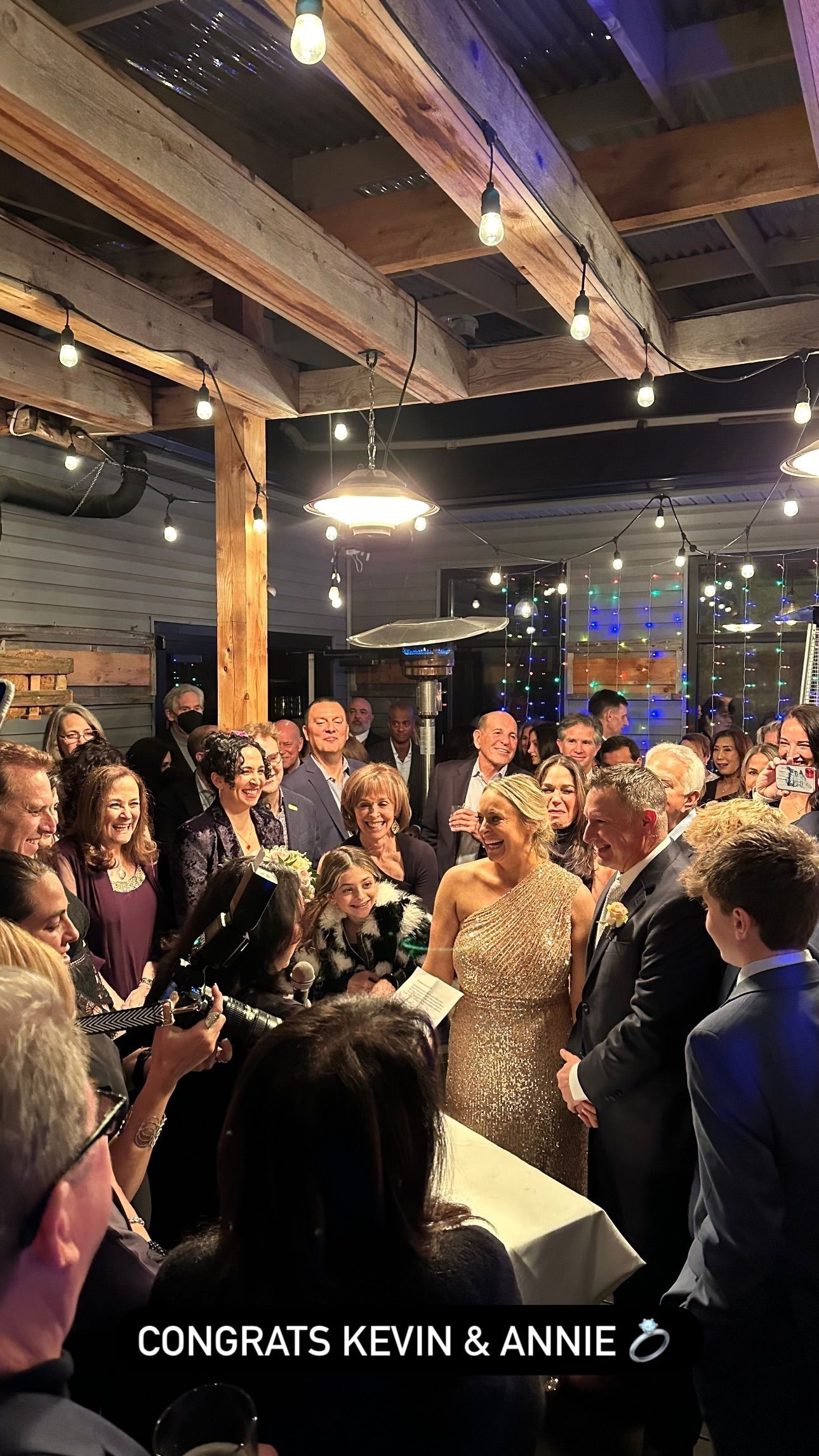 A group of people are standing around a table at a wedding reception.