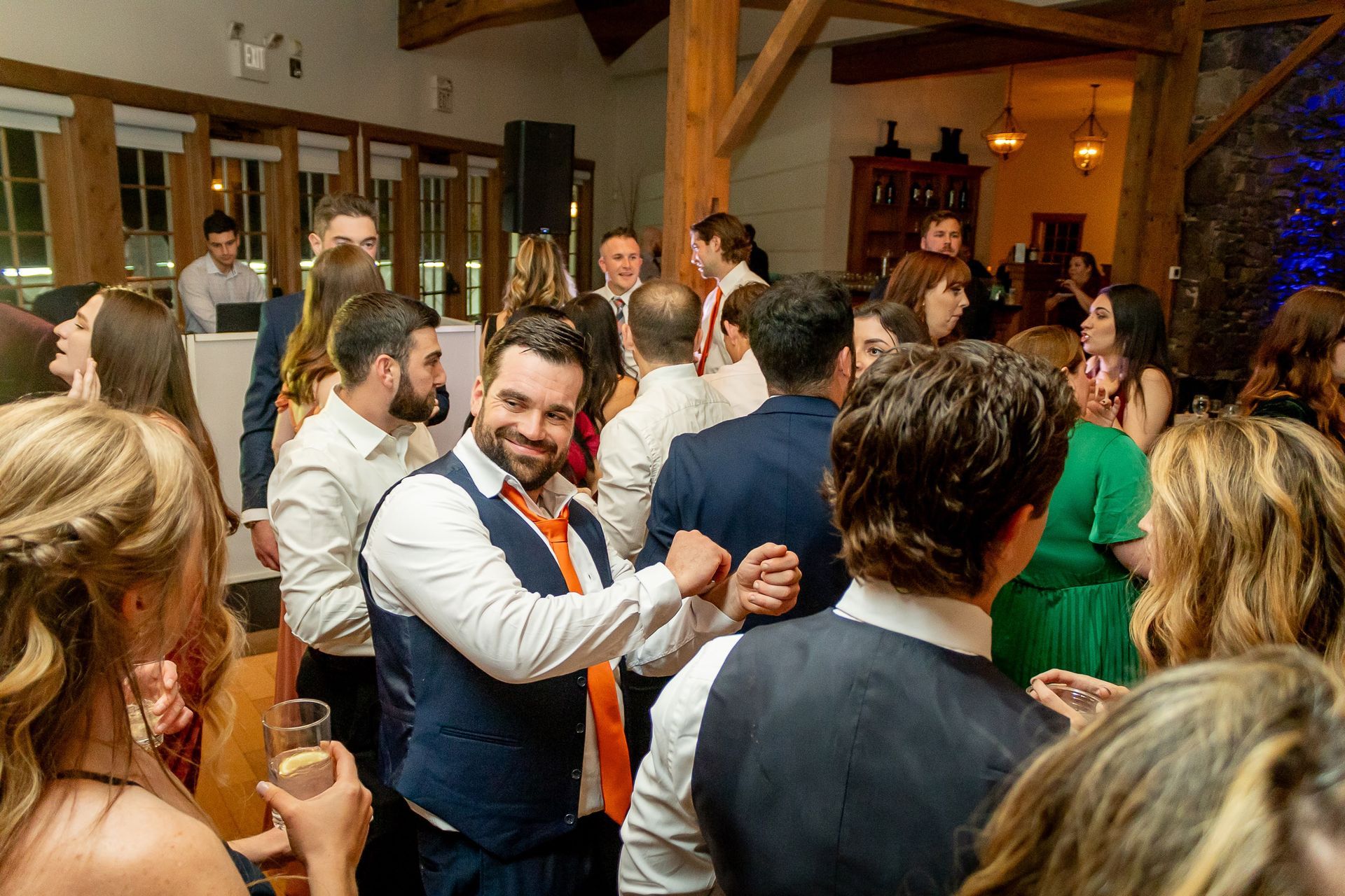 Packed dance floor filled with guests celebrating and dancing at a lively wedding reception.