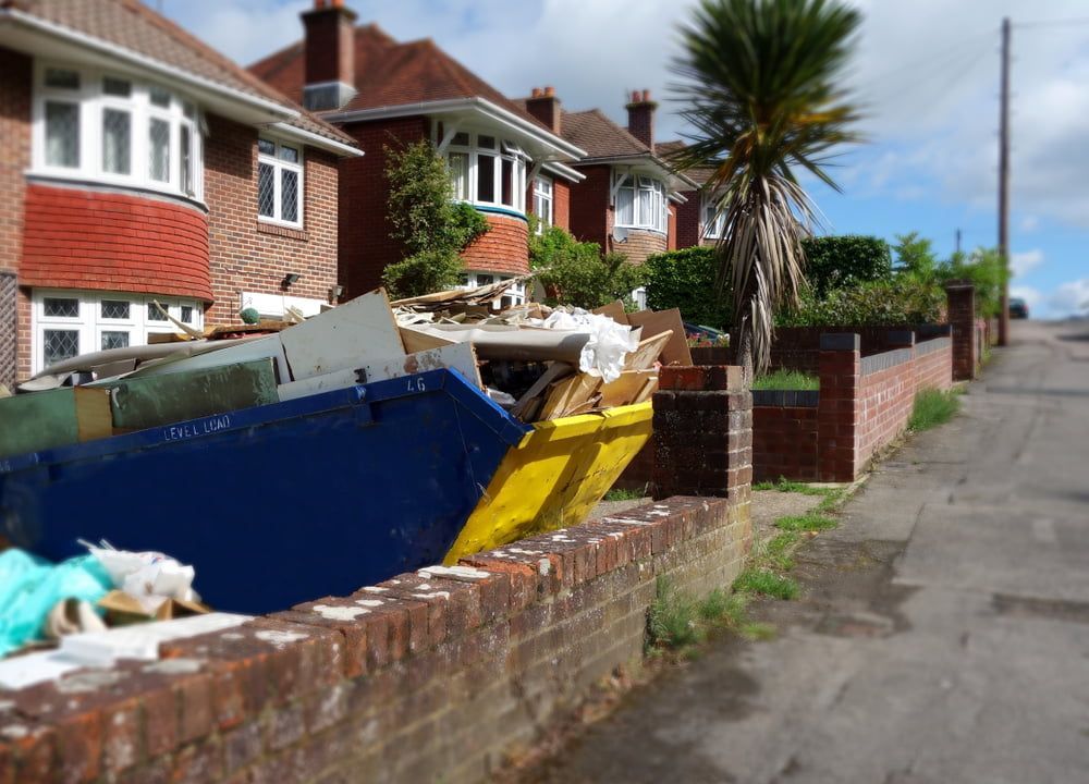A Dumpster is Sitting on the Side of the Road Next to a Brick Wall — Bins on Rims in Kempsey, NSW