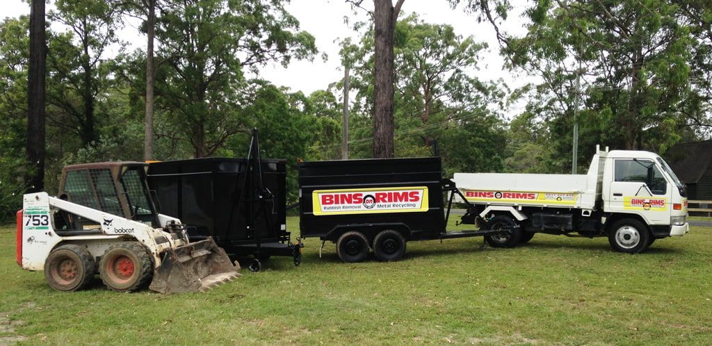 A White Truck With a Trailer Attached to It is Parked in a Grassy Field — Bins on Rims in Kempsey, NSW