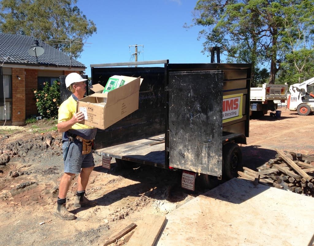 A Man Standing Next to a Dumpster on It — Bins on Rims in Kempsey, NSW