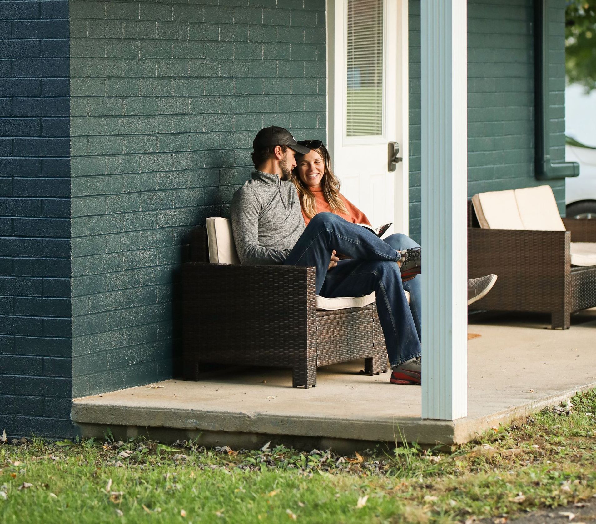 A man and a woman are sitting on the porch of a house