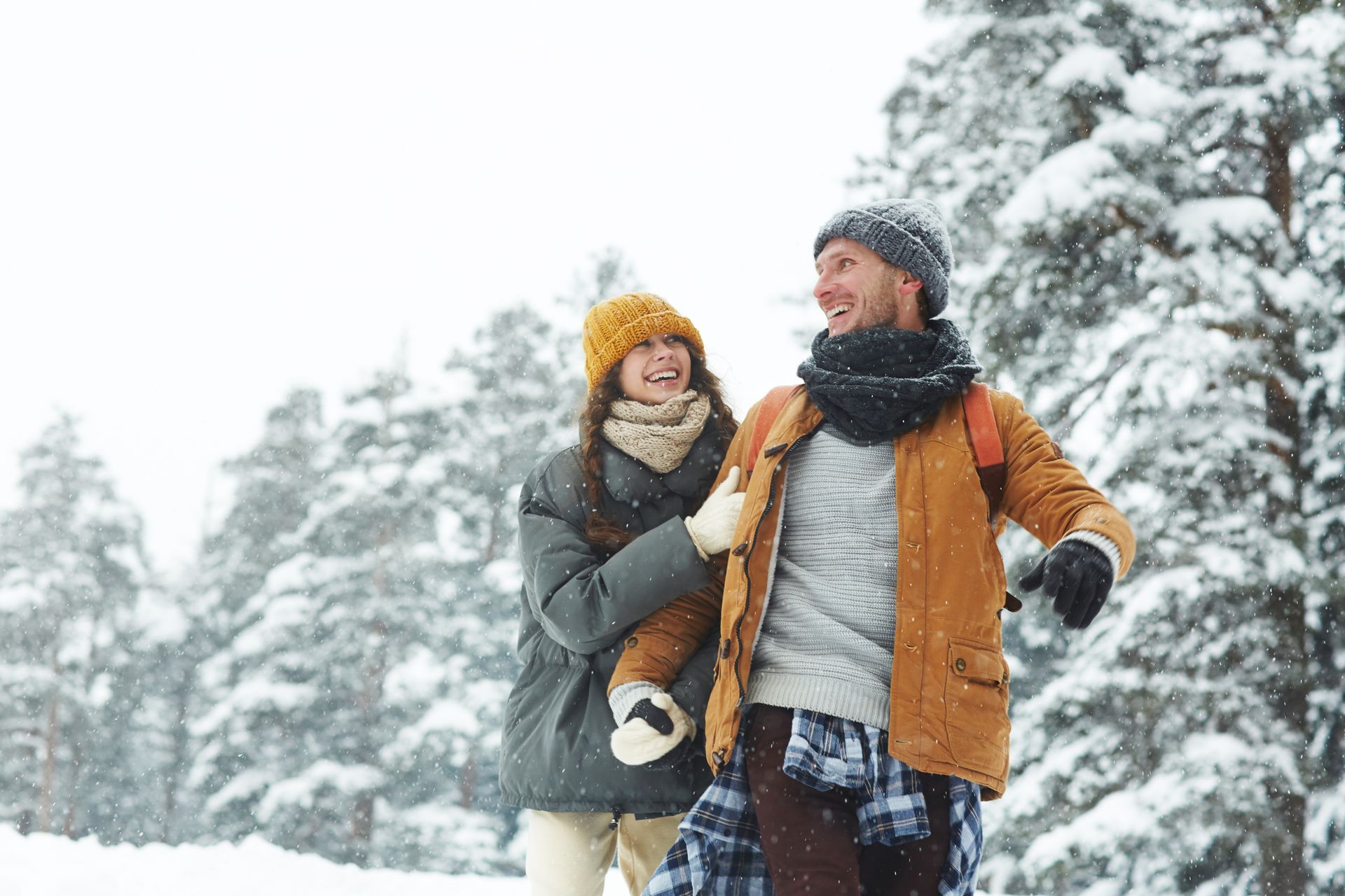 A man and a woman are walking in the snow.