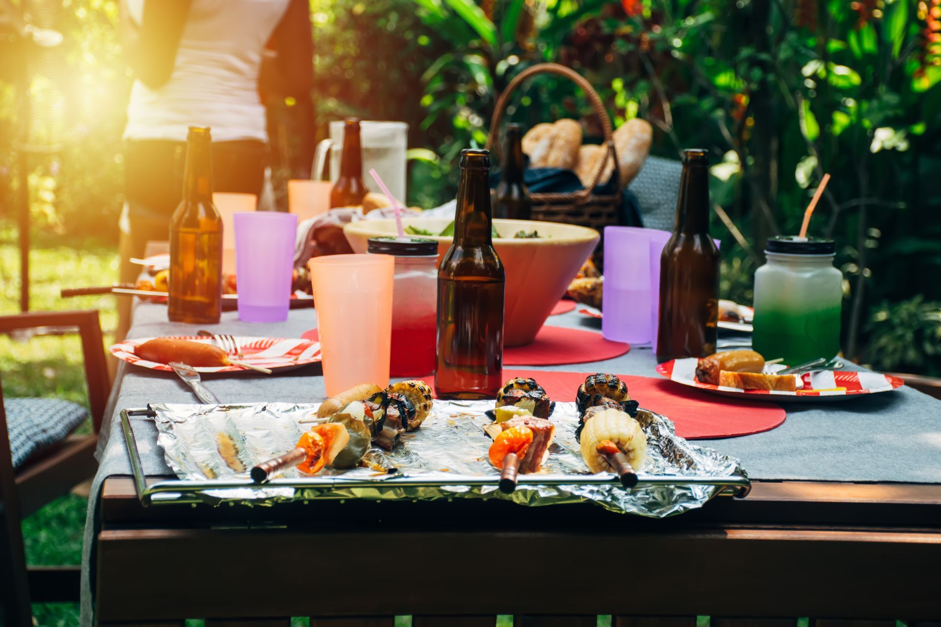 A table topped with plates of food and bottles of beer.