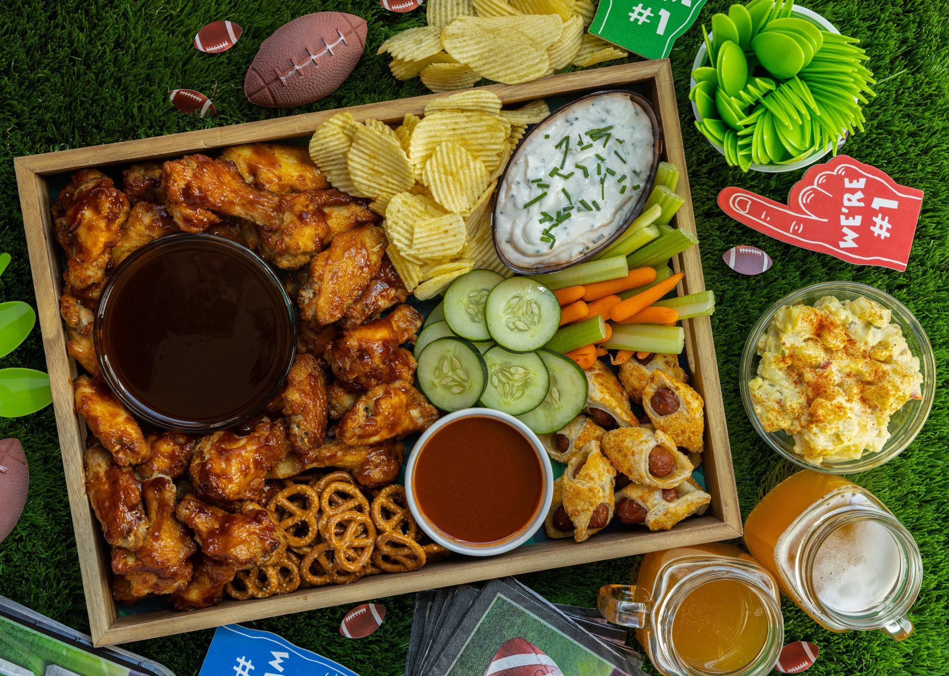 A tray of food is sitting on top of a lush green field.