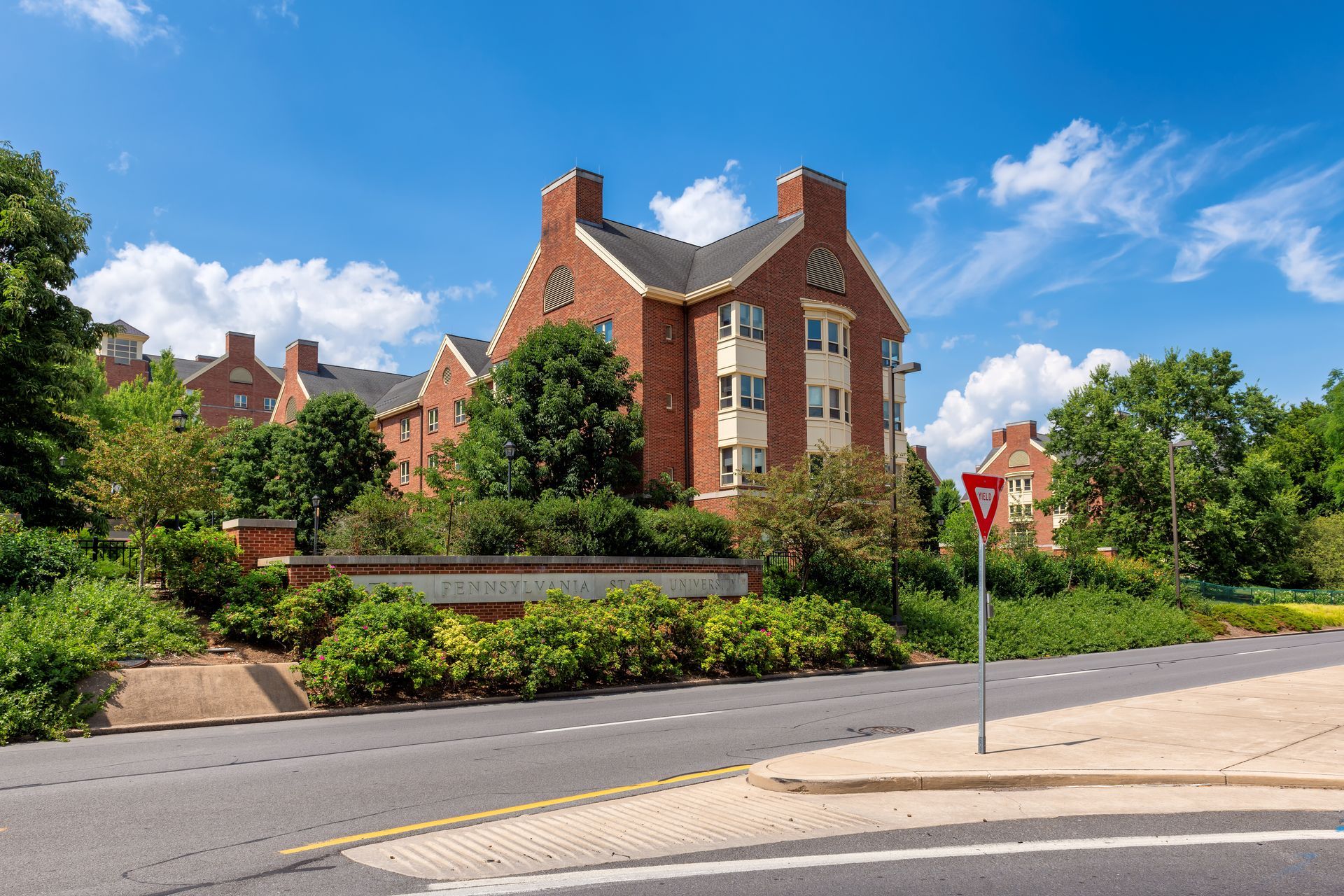 A large brick building is sitting on the corner of a street.
