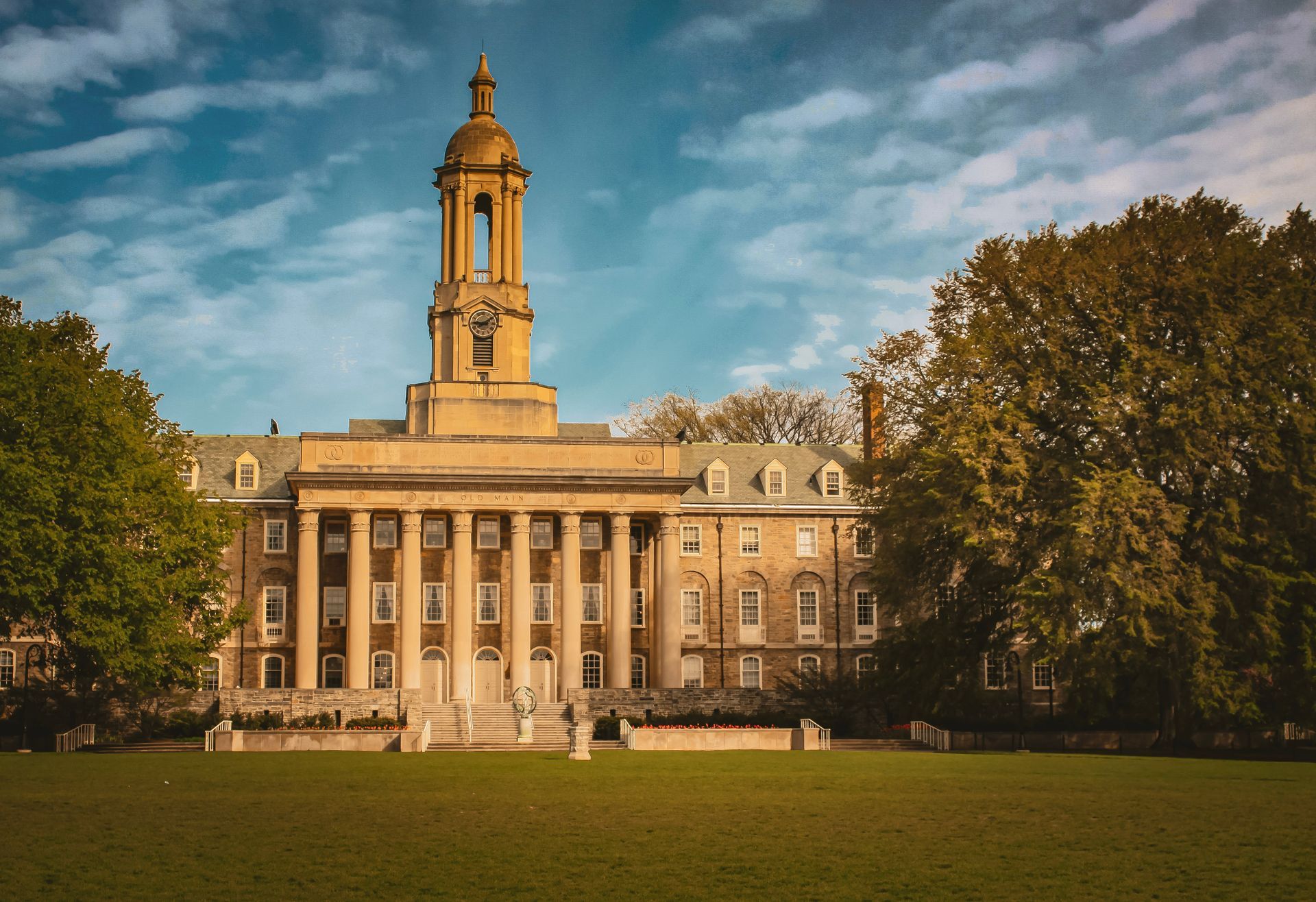 A large building with a clock tower on top of it at Pennsylvania State University.