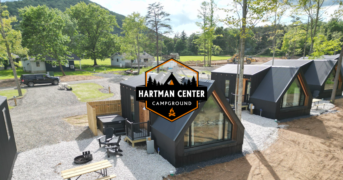 A group of tiny houses are sitting next to each other on top of a dirt field.