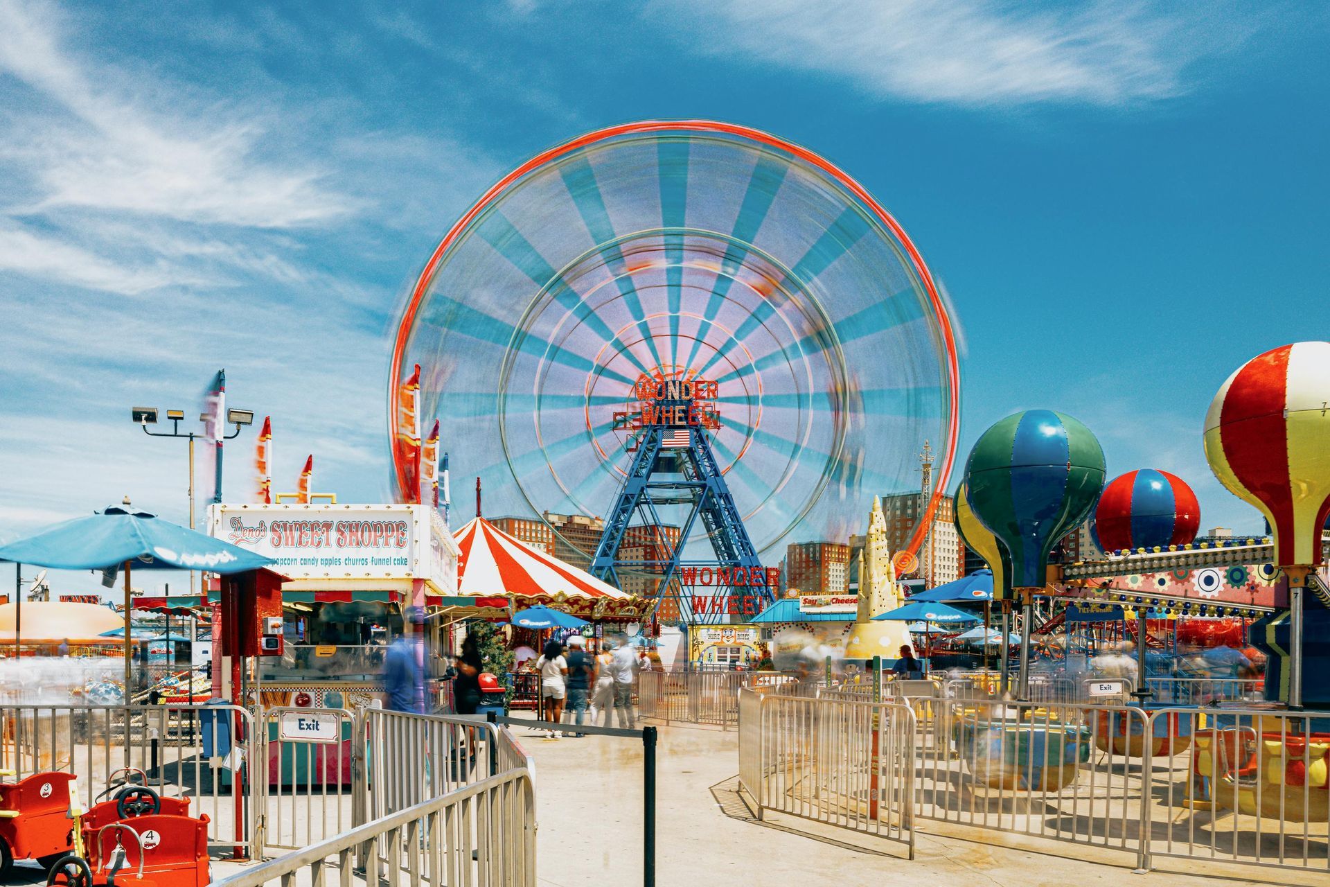 A carnival with a ferris wheel and hot air balloons