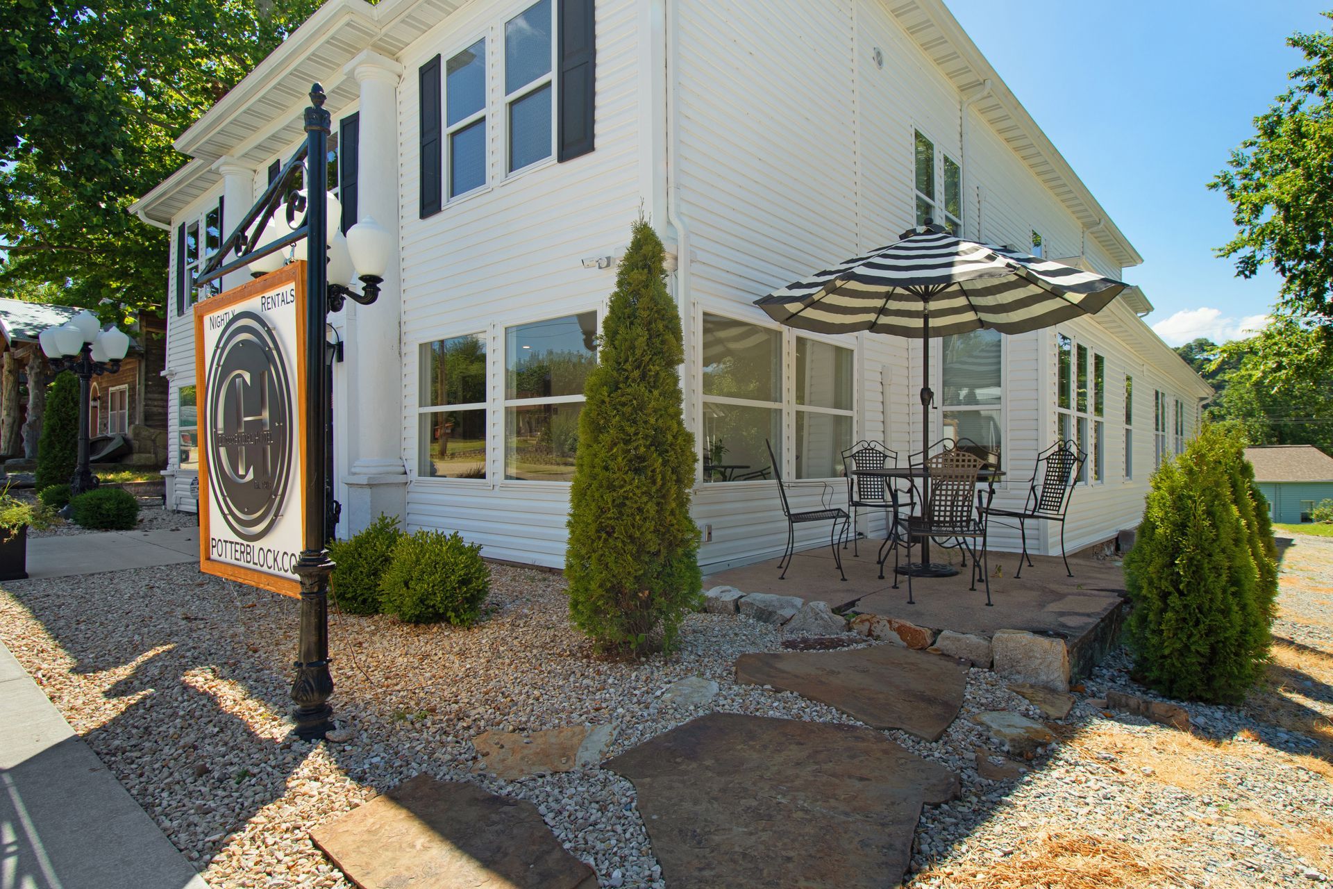 A white house with a patio and umbrellas in front of it