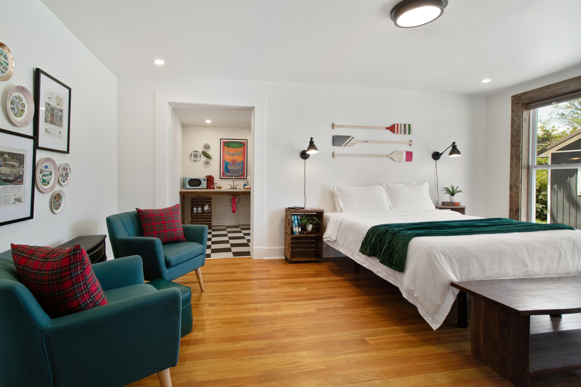 A bedroom with a large bed , two chairs and a bench.