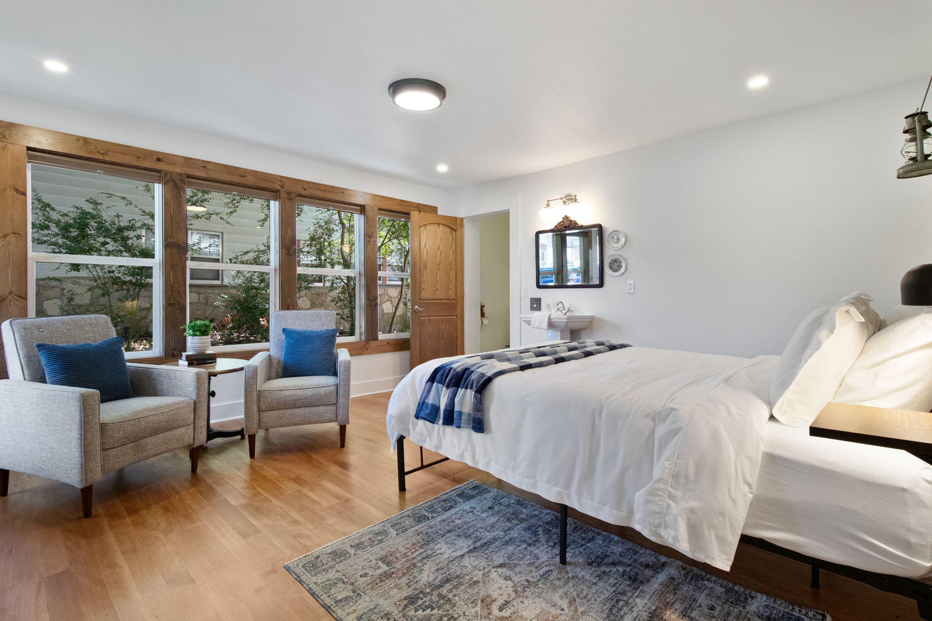 A bedroom with a bed , chairs , and a rug.