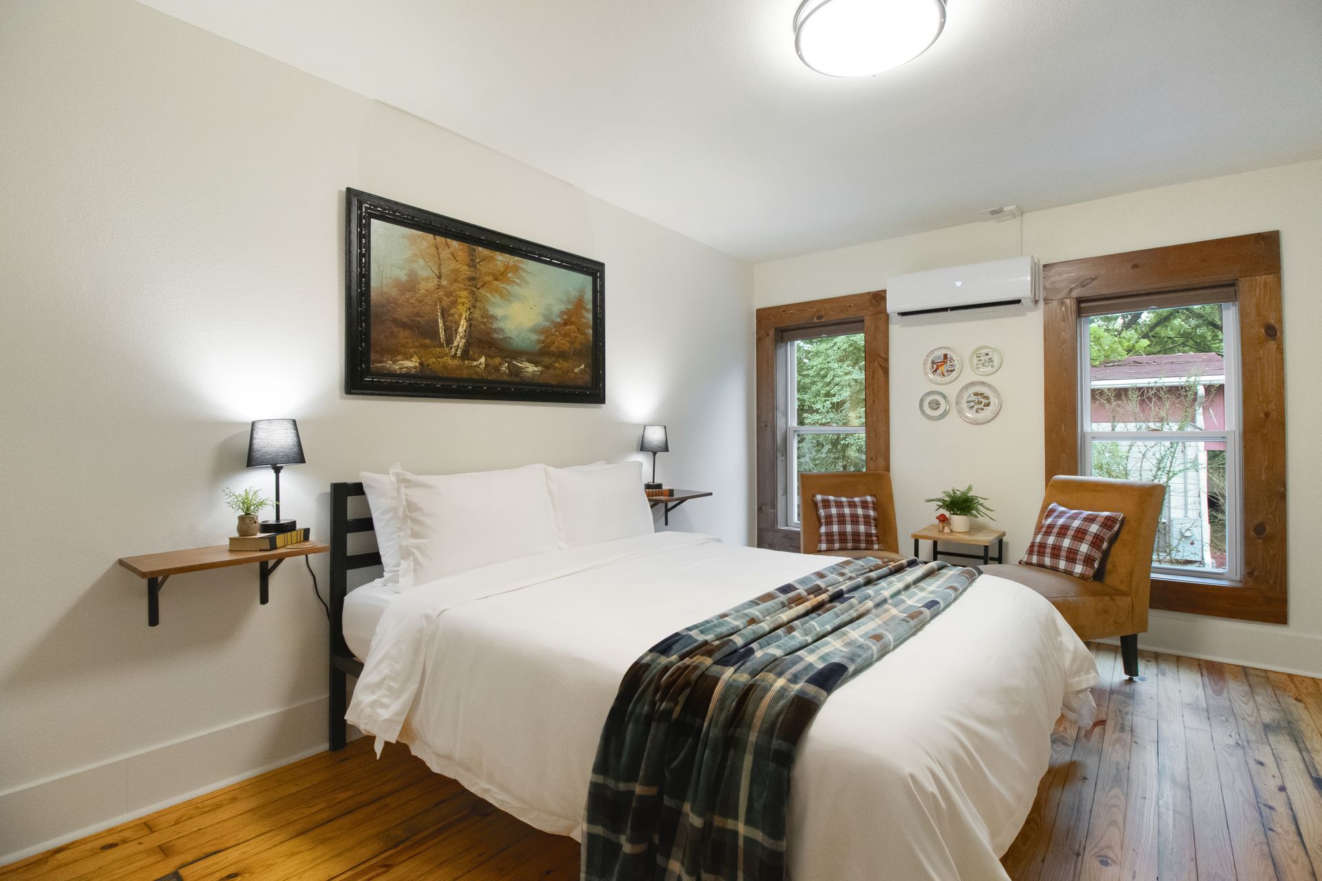 A bedroom with a king size bed and a painting on the wall.