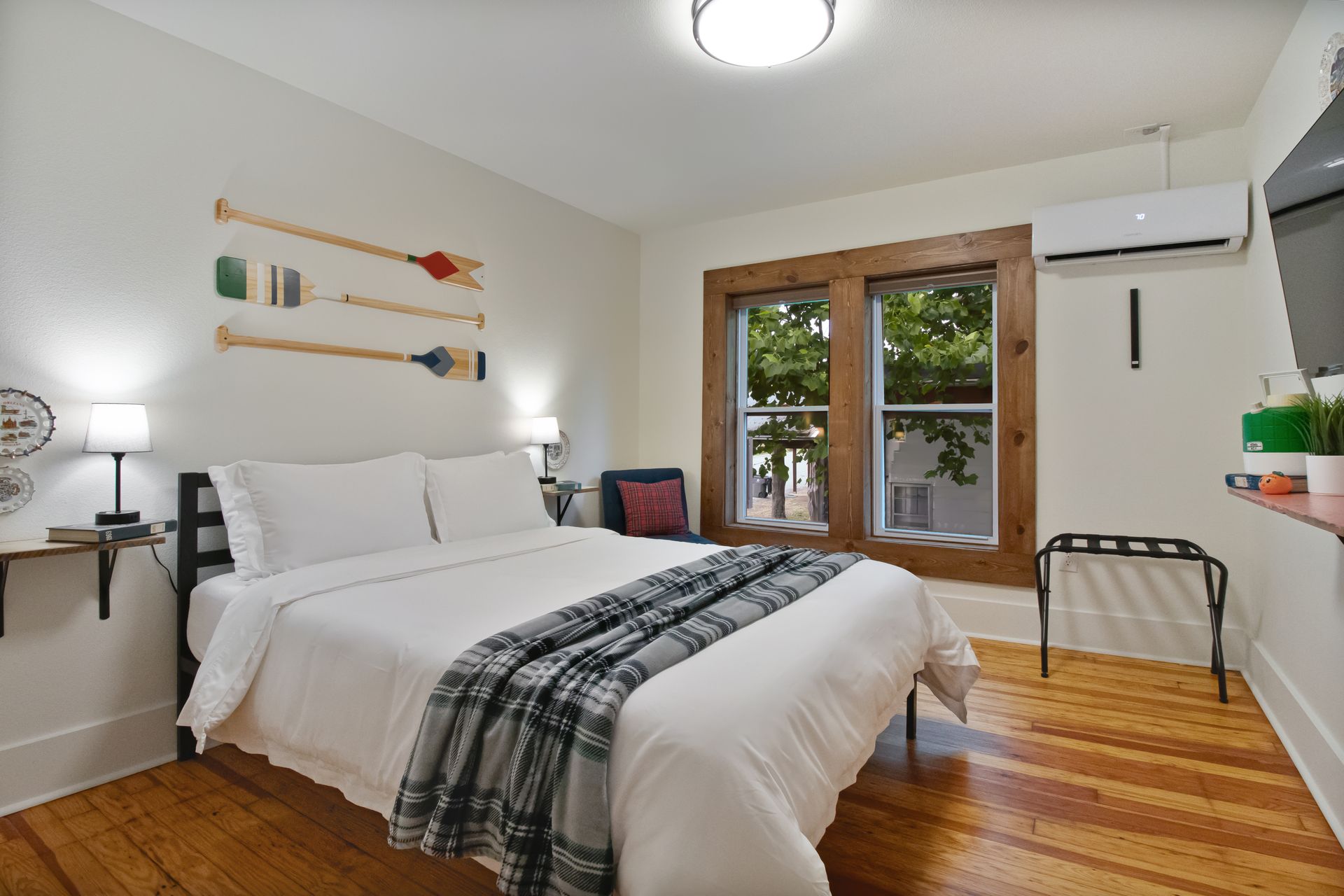 A bedroom with a king size bed , wooden floors , and a window.
