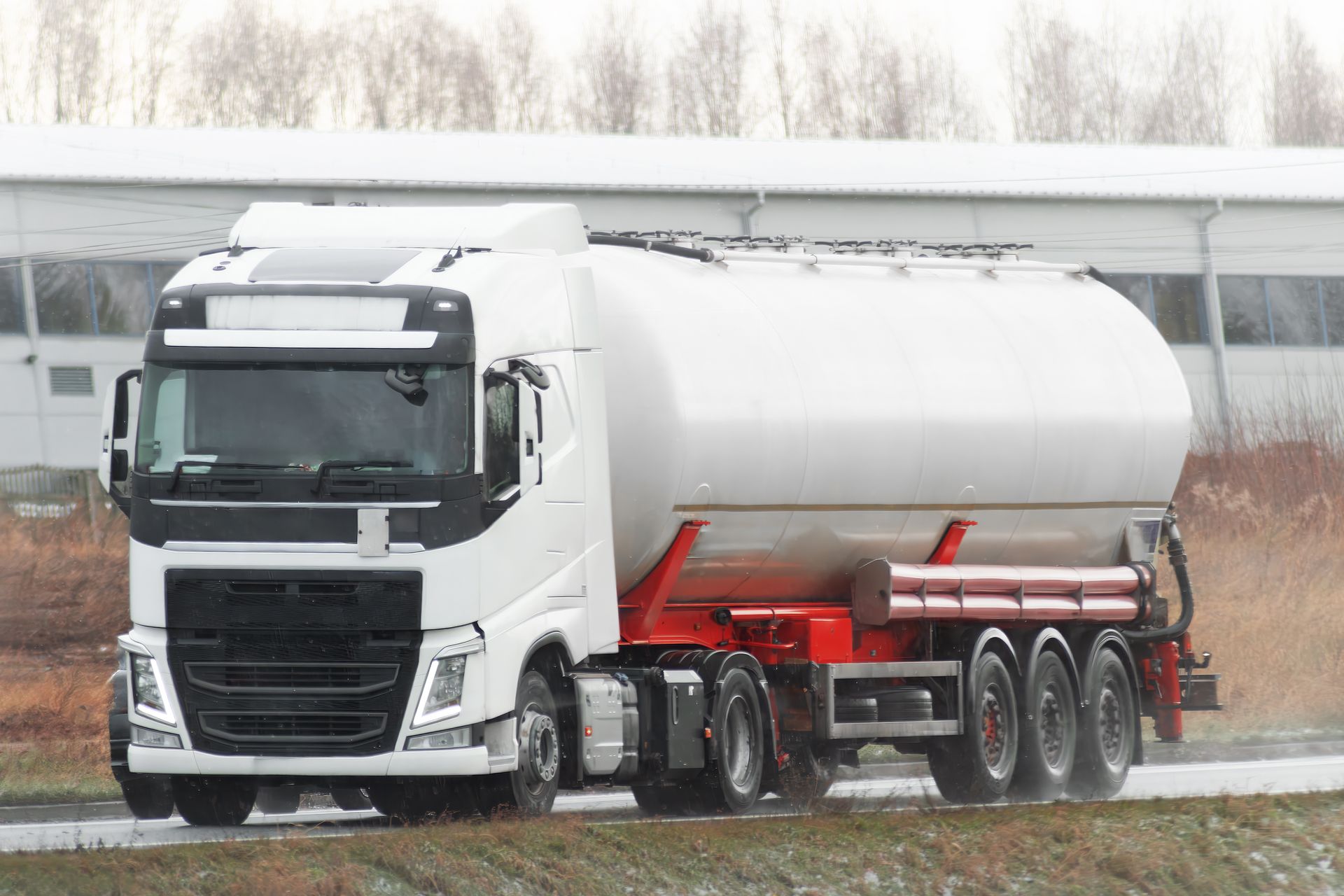 Propane delivery truck moving with caution on a snowy winter road. Propane delivery truck moving with caution on a snowy winter road.