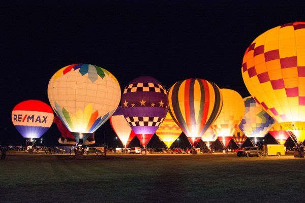 Hot air balloons glowing at night.