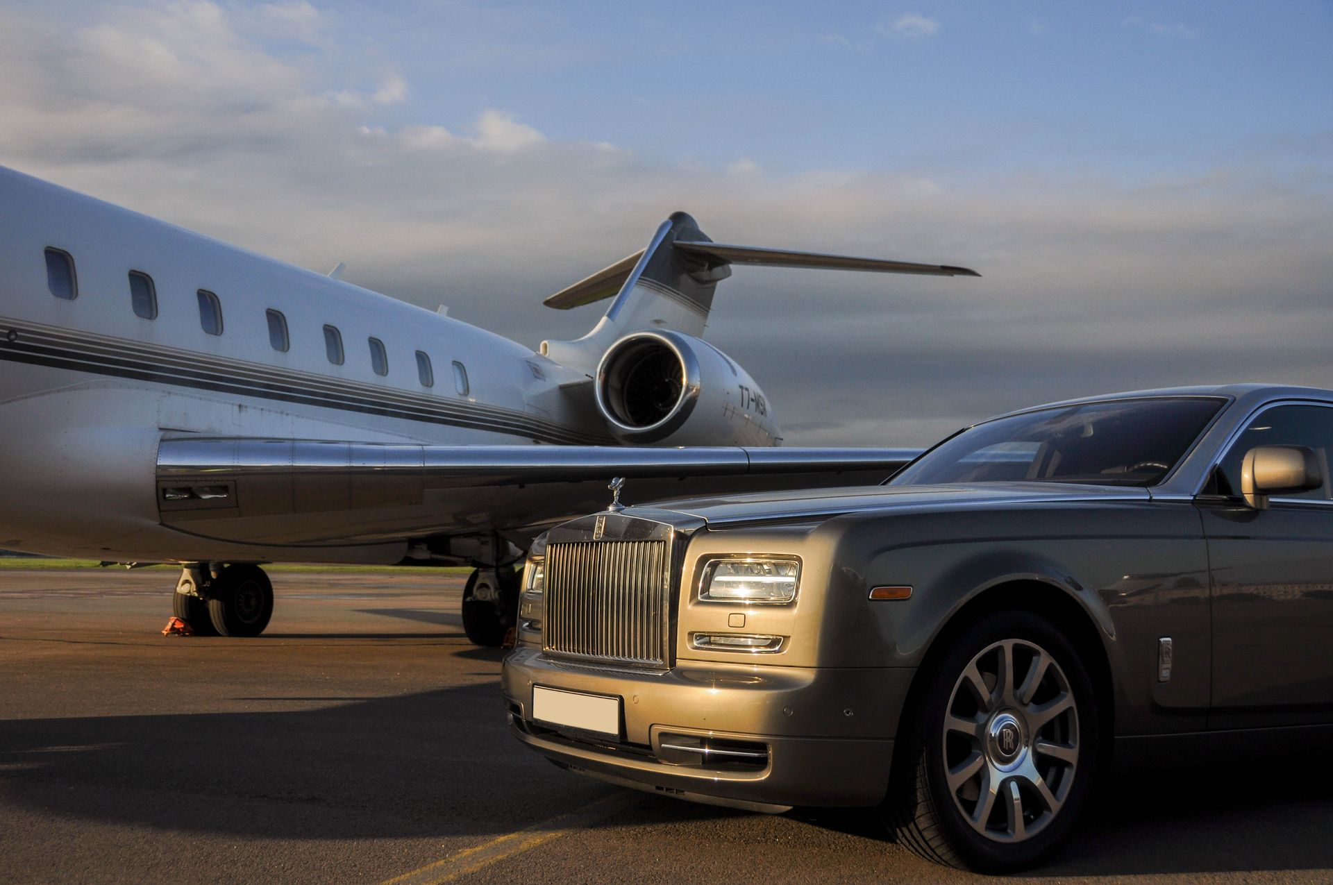 A car parked on a tarmac next to a private jet