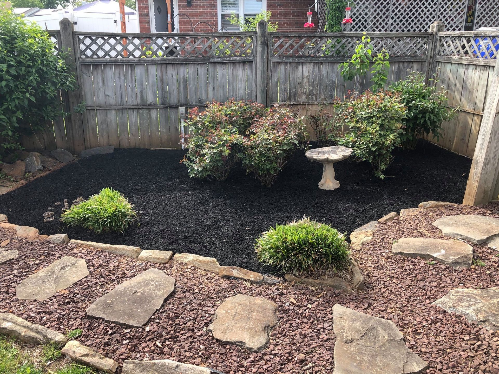 There is a bird bath in the middle of the garden.