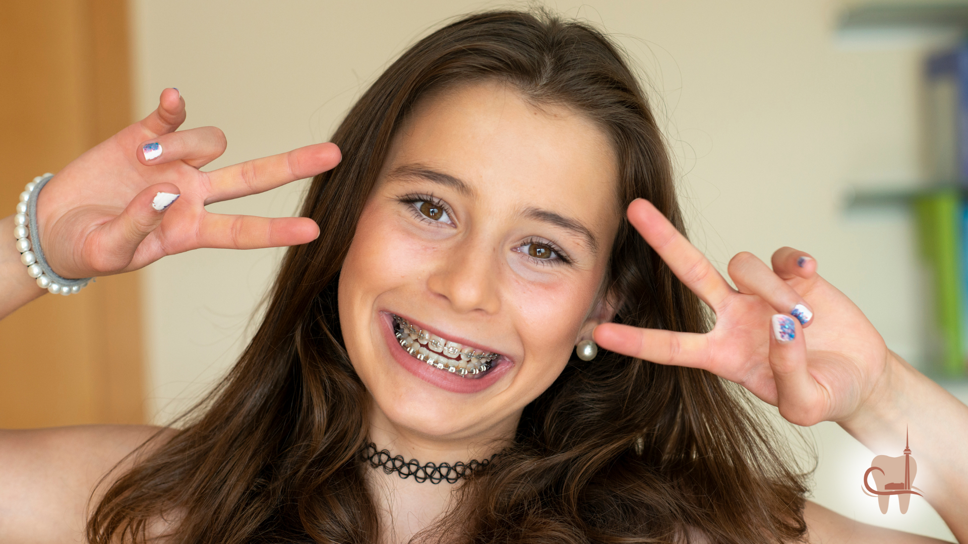 Teenage girl with braces smiles, making peace signs with painted nails; choker necklace.