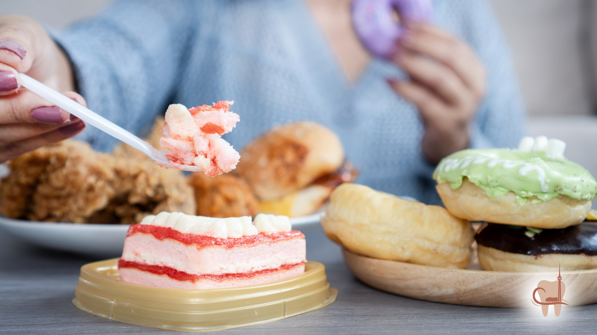 Person eating cake, surrounded by donuts, fried chicken, and other junk food.