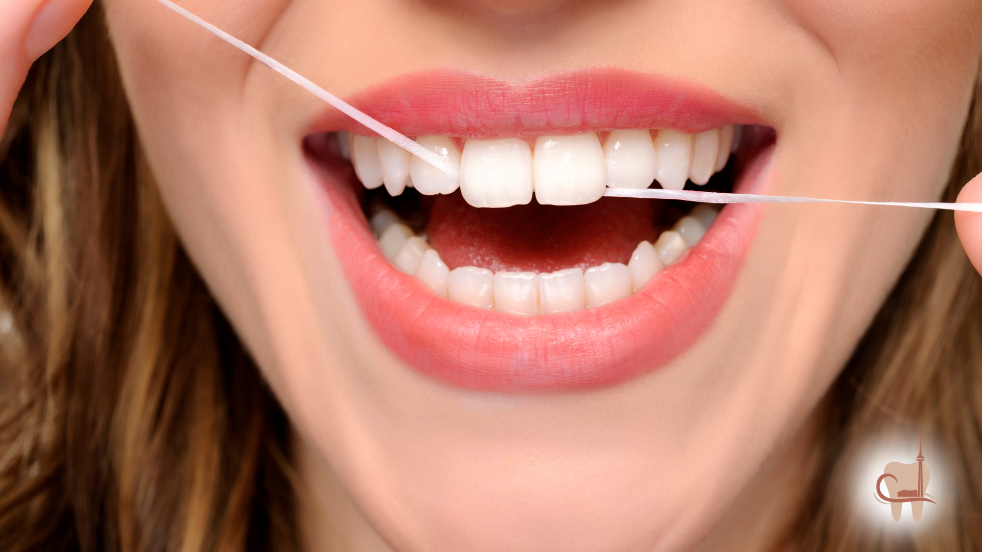 Person flossing teeth, white teeth, pink lips, open mouth, close-up.