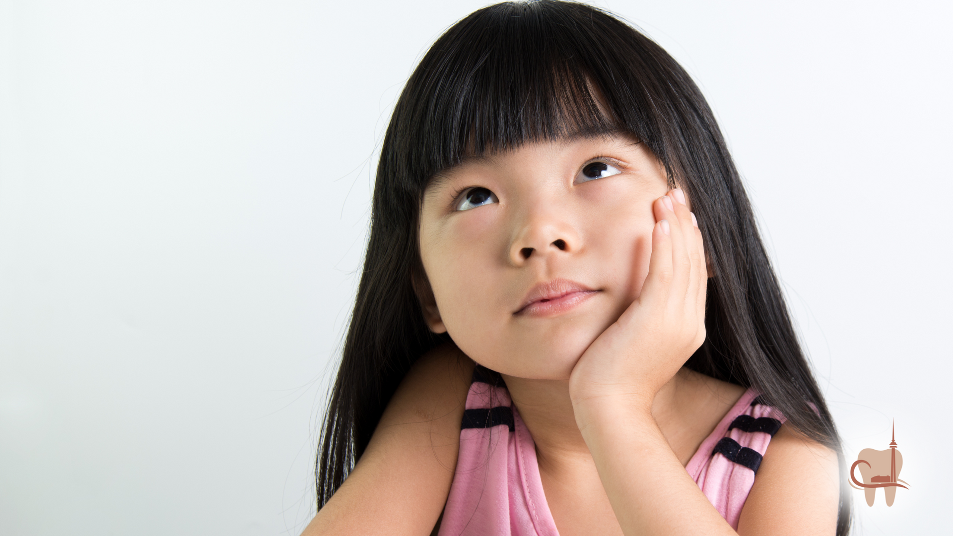 Asian girl with long black hair, pink top, looking up thoughtfully, hand on cheek.