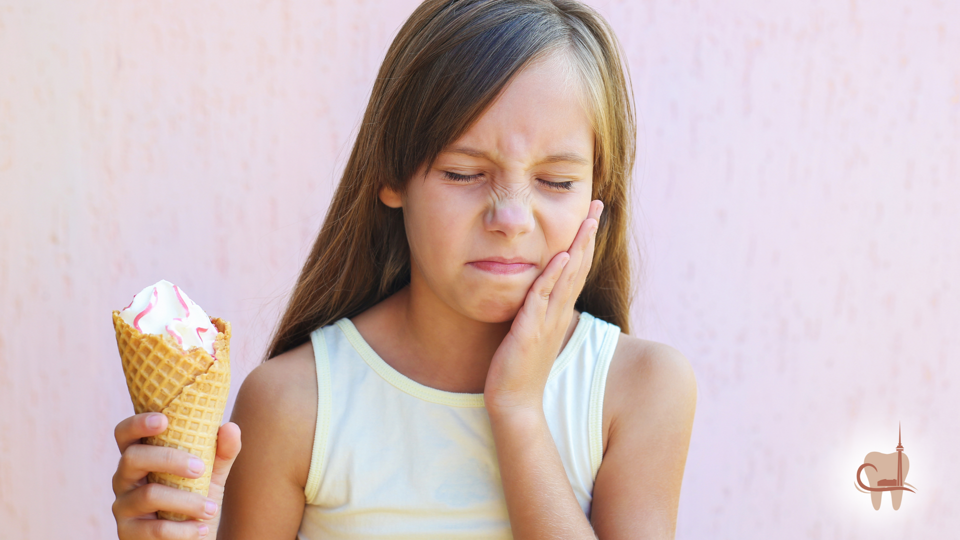 Girl holding ice cream, experiencing tooth sensitivity, grimacing and touching cheek.