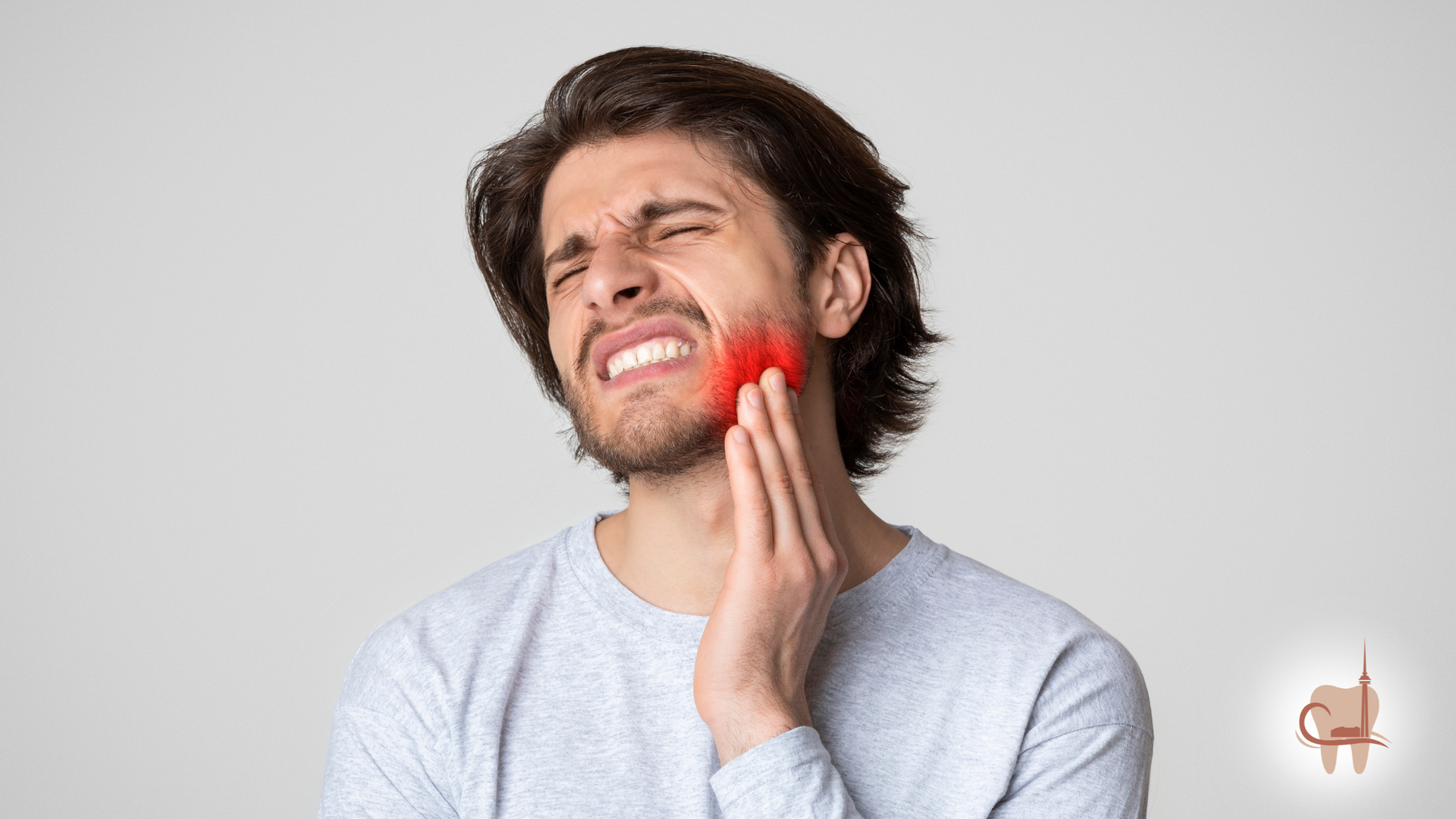 Man with pained expression holding his jaw, showing red area indicating toothache.